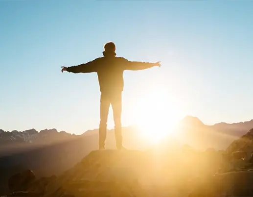 man with outstretched arms after hiking