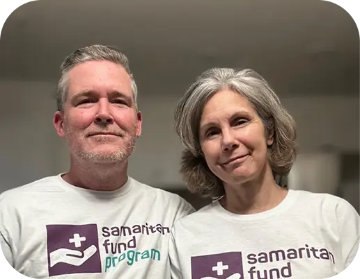 Man and wife standing next to each other in Samaritan Fund Foundation shirts