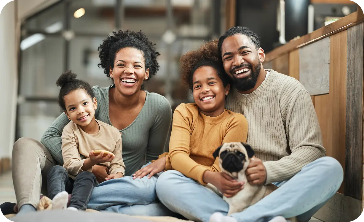 Family sat with two daughters and a puppy